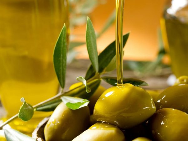 Масло оливы льётся на оливки