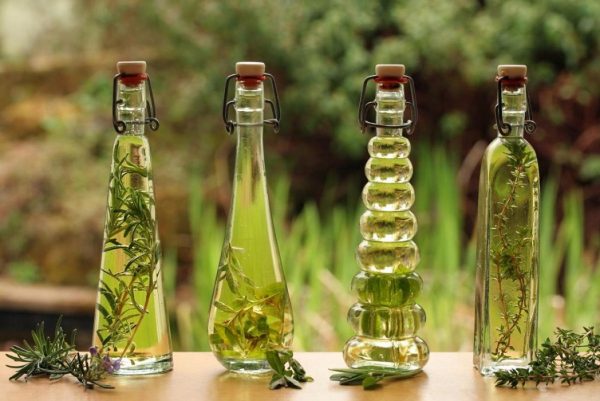 Бутылки с маслом и растениями в нём