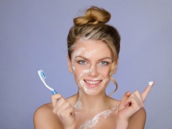 Девушка с зубной щёткой и следами пасты на лице